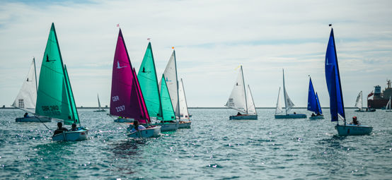 a number of sailing dinghies racing in Portland Harbour on a beautiful sunny day