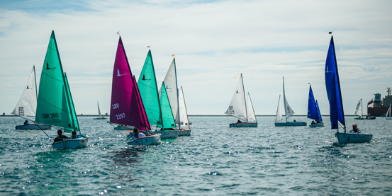 a number of sailing dinghies racing in Portland Harbour on a beautiful sunny day