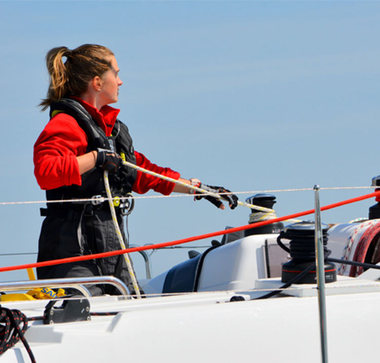 woman on board yacht pulling rope