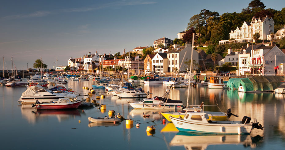 beautiful harbour with various different boats moored up in line in the water