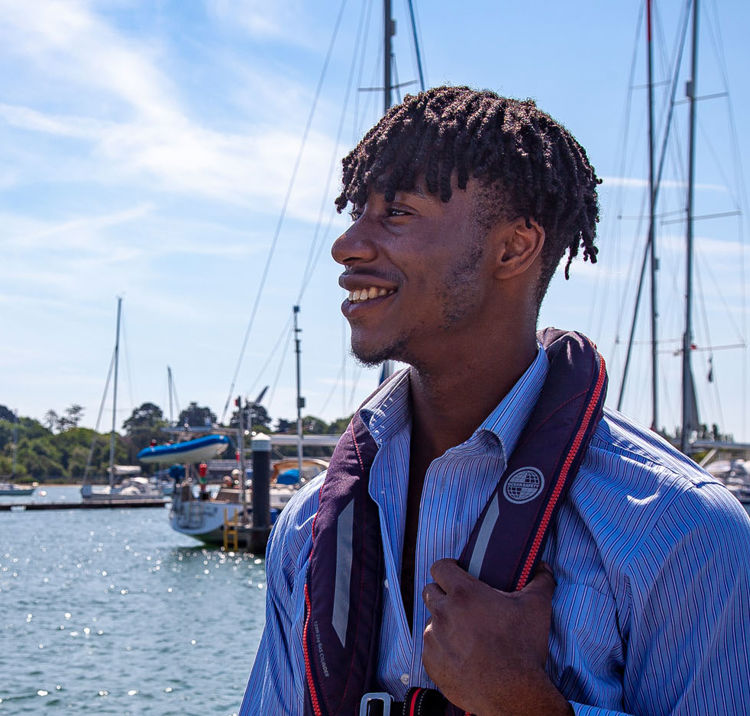 sailor wearing lifejacket looking out at water