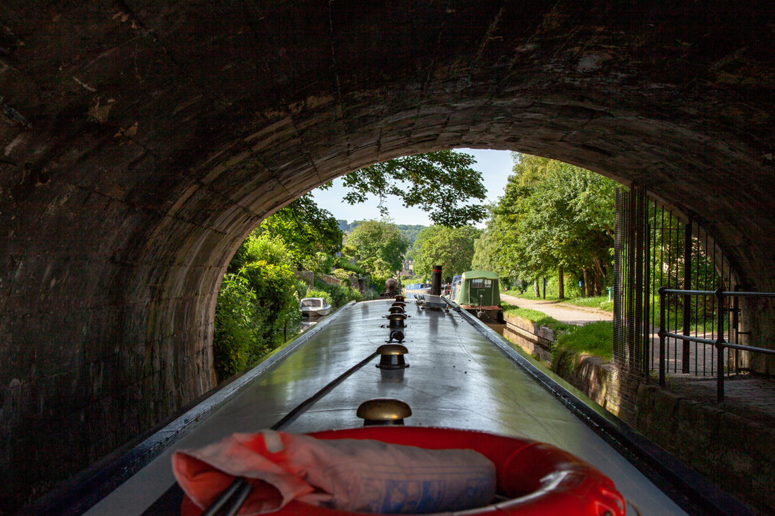 POV shot of canal boat going under bridge