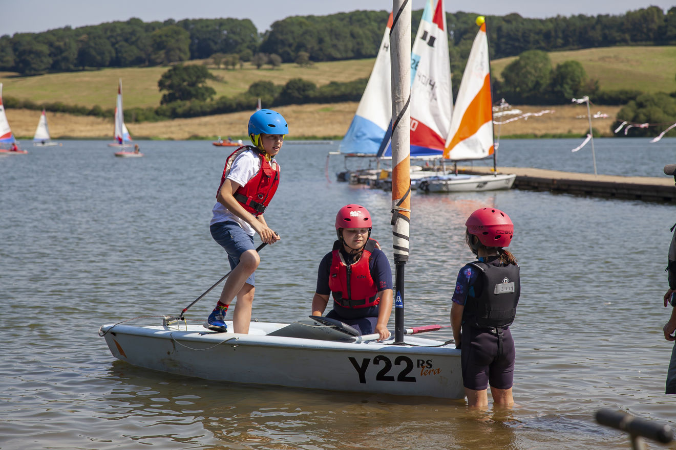 Mid shot of three children during a dinghy sailing session