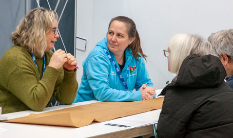 Mid shot of four Connected Conference employees discussing an activity