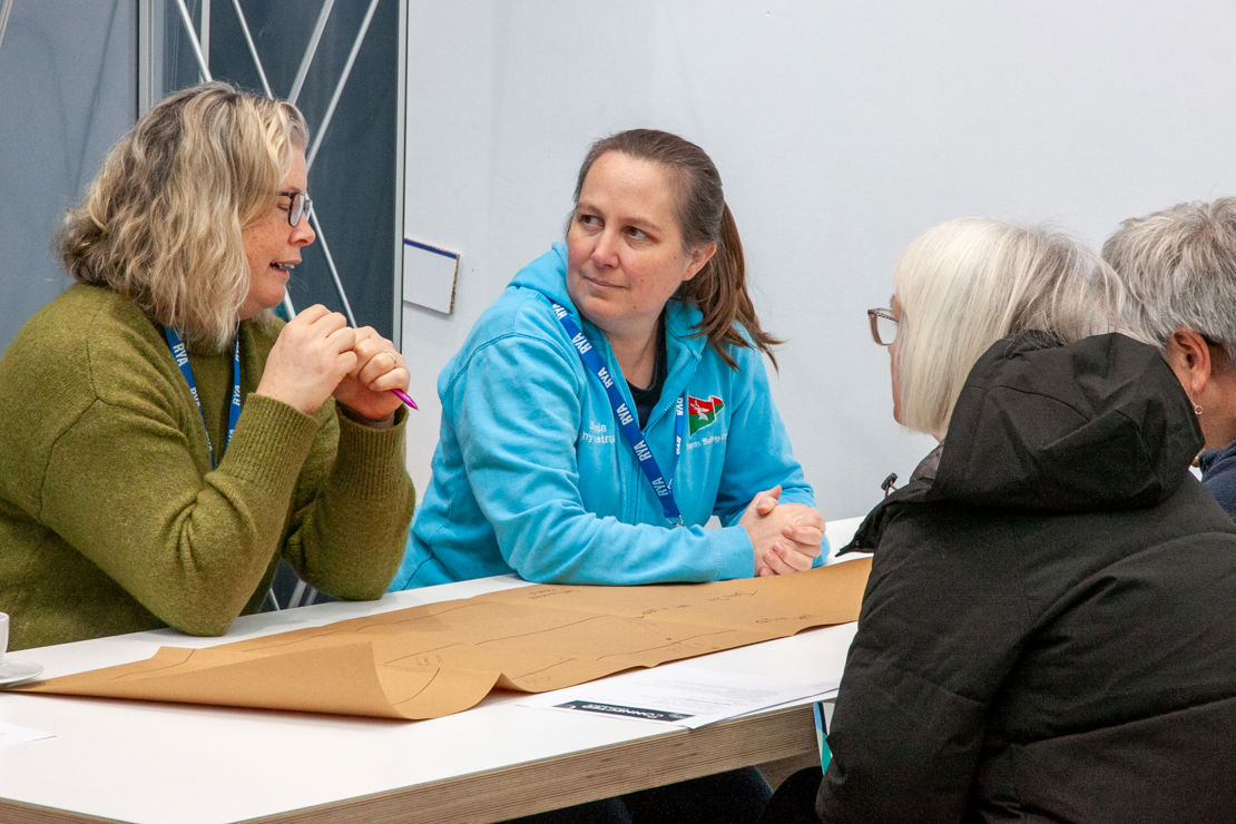 Mid shot of four Connected Conference employees discussing an activity