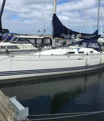 A sail boat moored on a jetty with its sails away