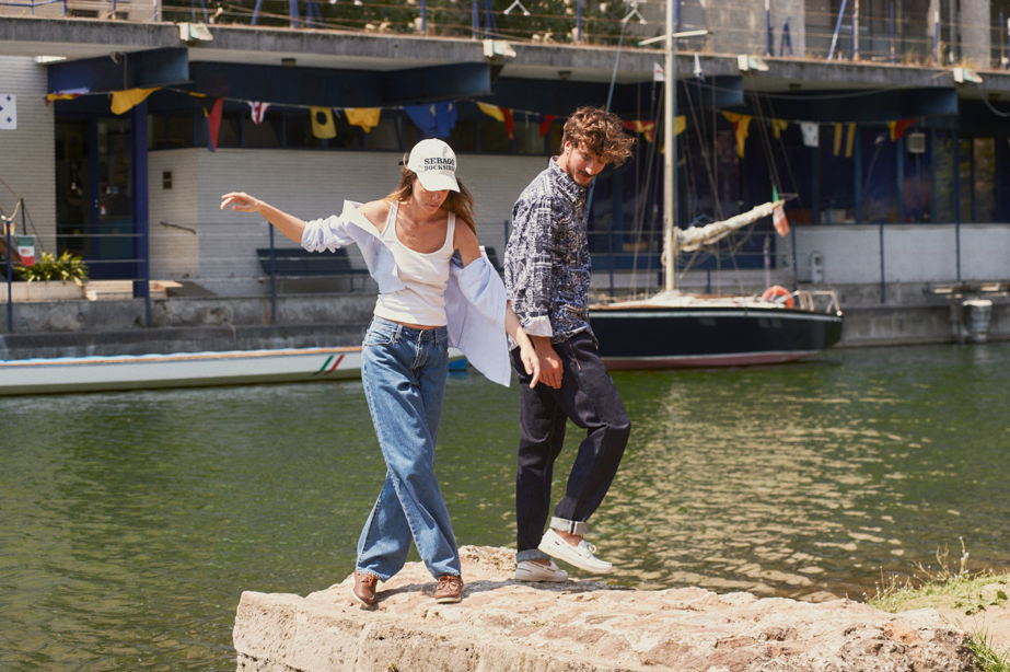 man and woman standing on some rocks both wearing a pair of sebagos
