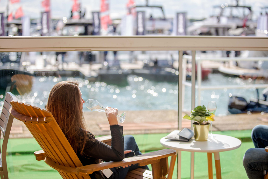 Woman in deckchair drinking by the water