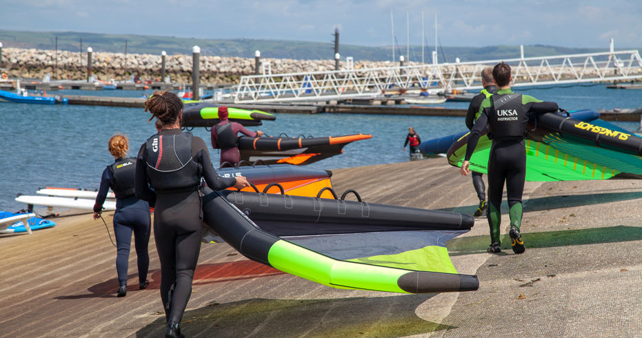 windsurfers walking to water from slipway