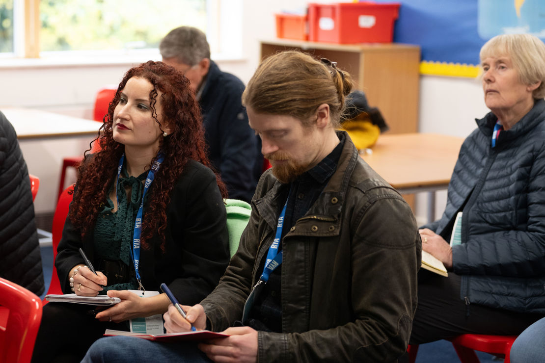 Midshot image of attendees taking notes