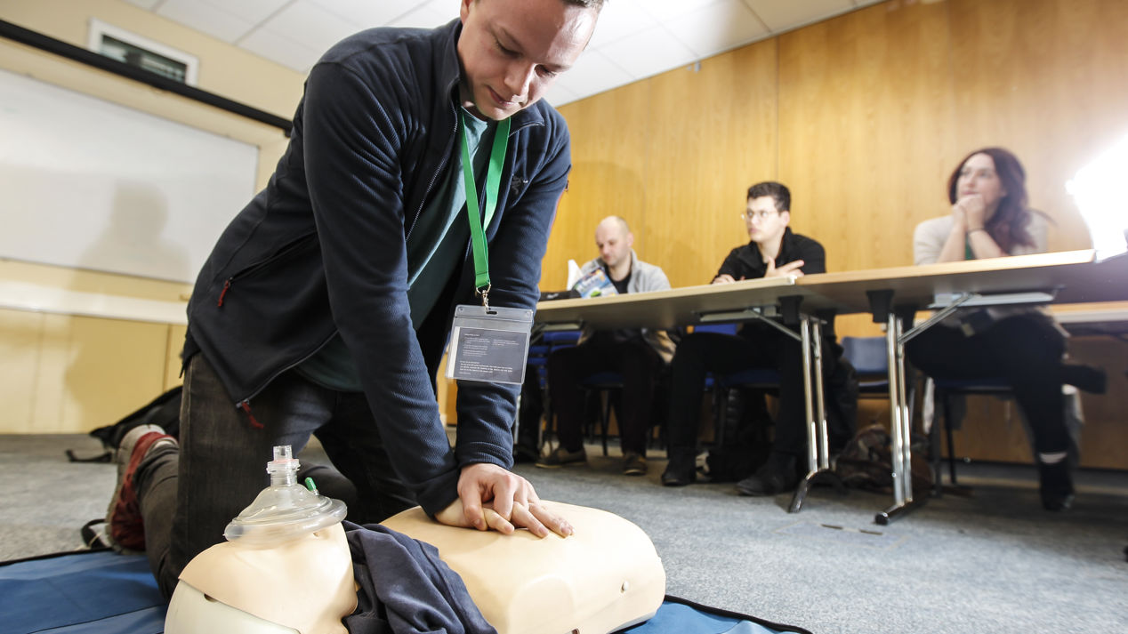 low shot of man performing CPR training on dummy