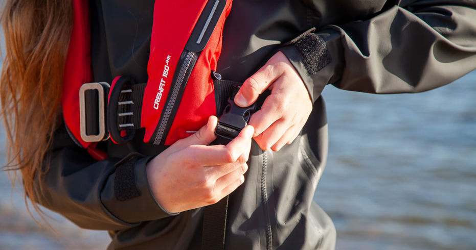 Girl securing leg strap on lifejacket