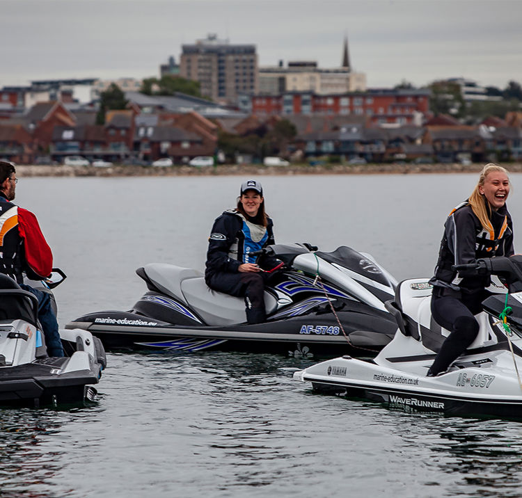 Three people on personal watercraft jet skis