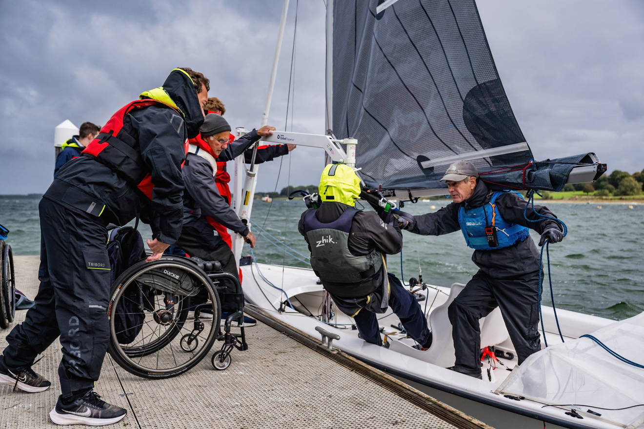 Wheelchair using sailor being lowered into boat