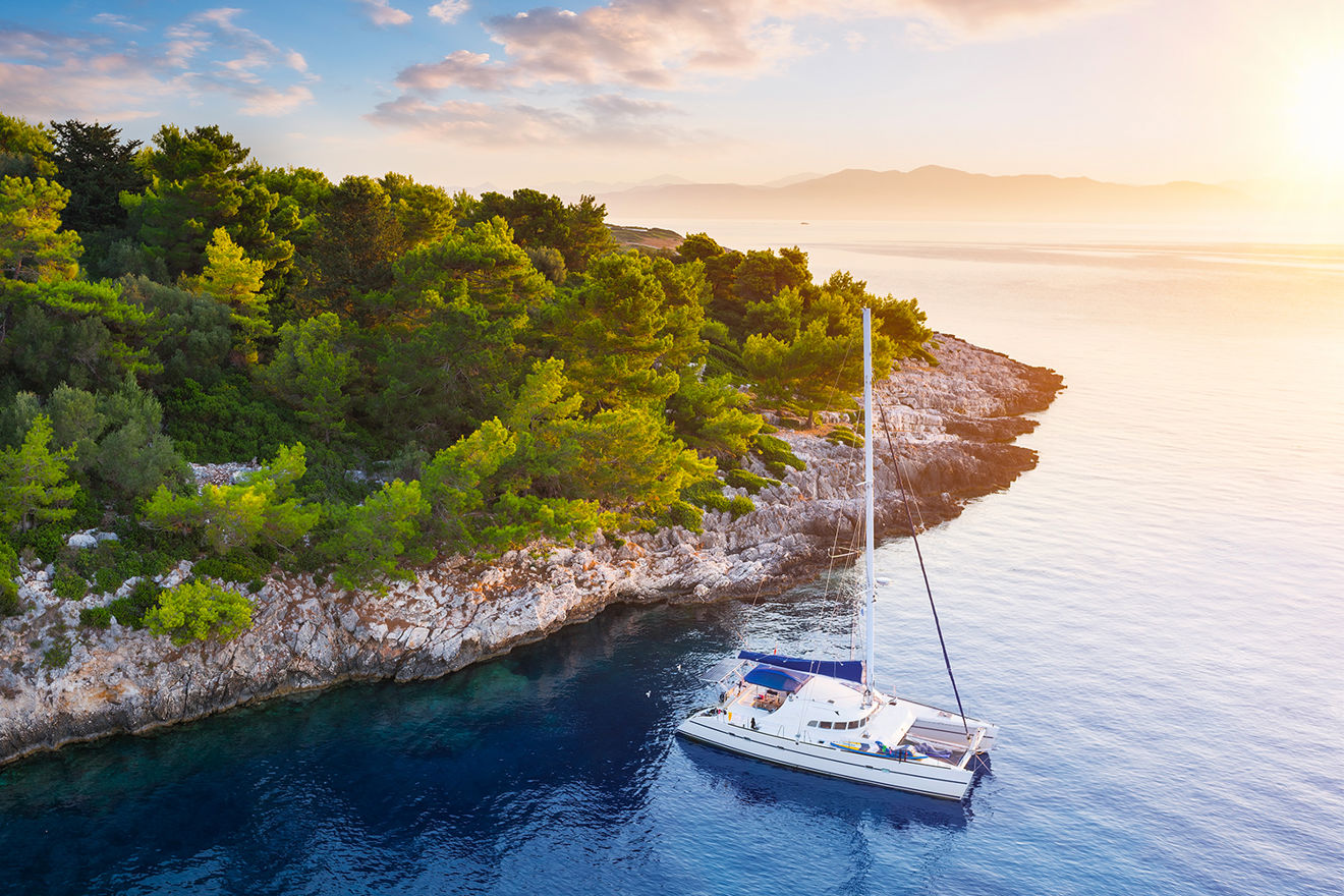 Catamaran in the ocean near an island during sunset