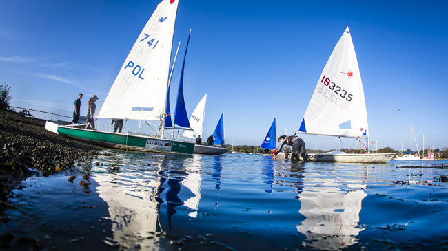 Long shot of group of sailors docking their dinghys