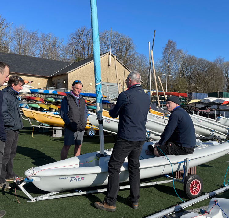 instructors stood around a dinghy on land