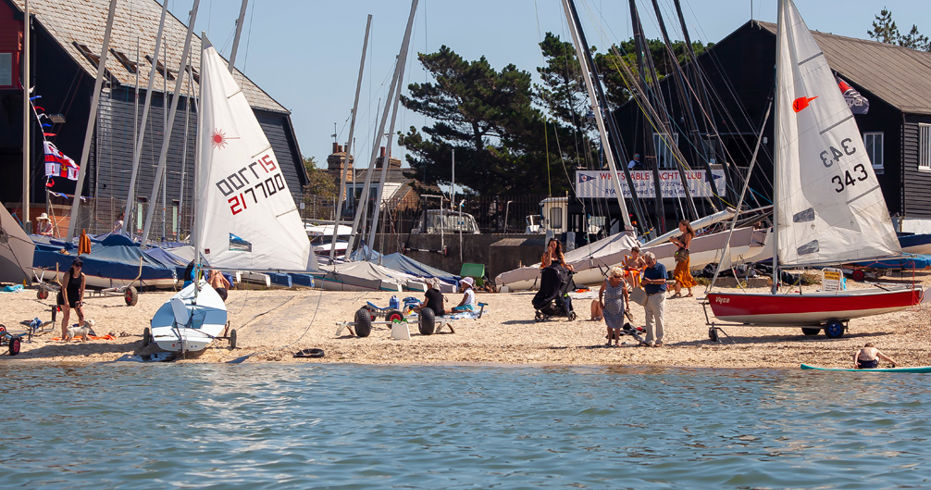 view from the water of the shore with various different boats and boards
