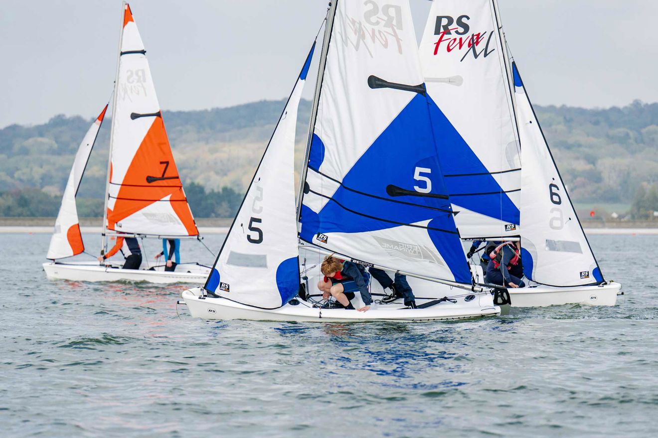 Close up of Eric Twiname racing dinghies on water