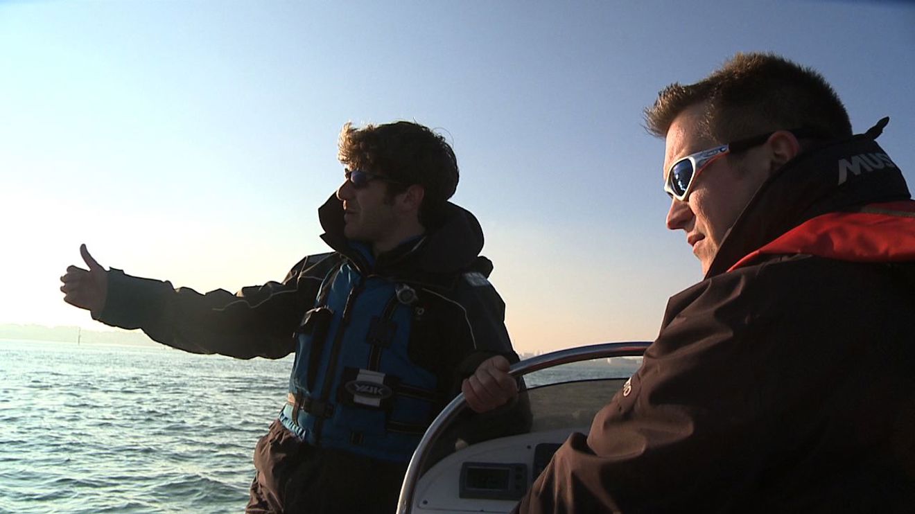 Two men on a powerboat during winter