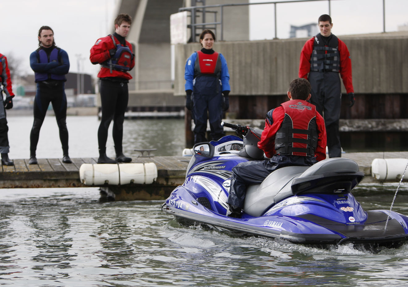 Man sat on PWC while training group stand on dock