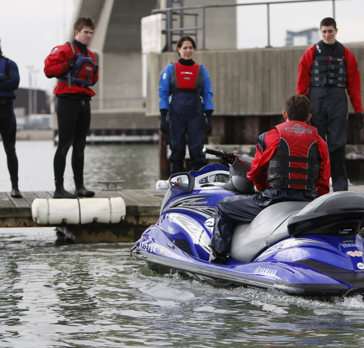 Man sat on PWC while training group stand on dock
