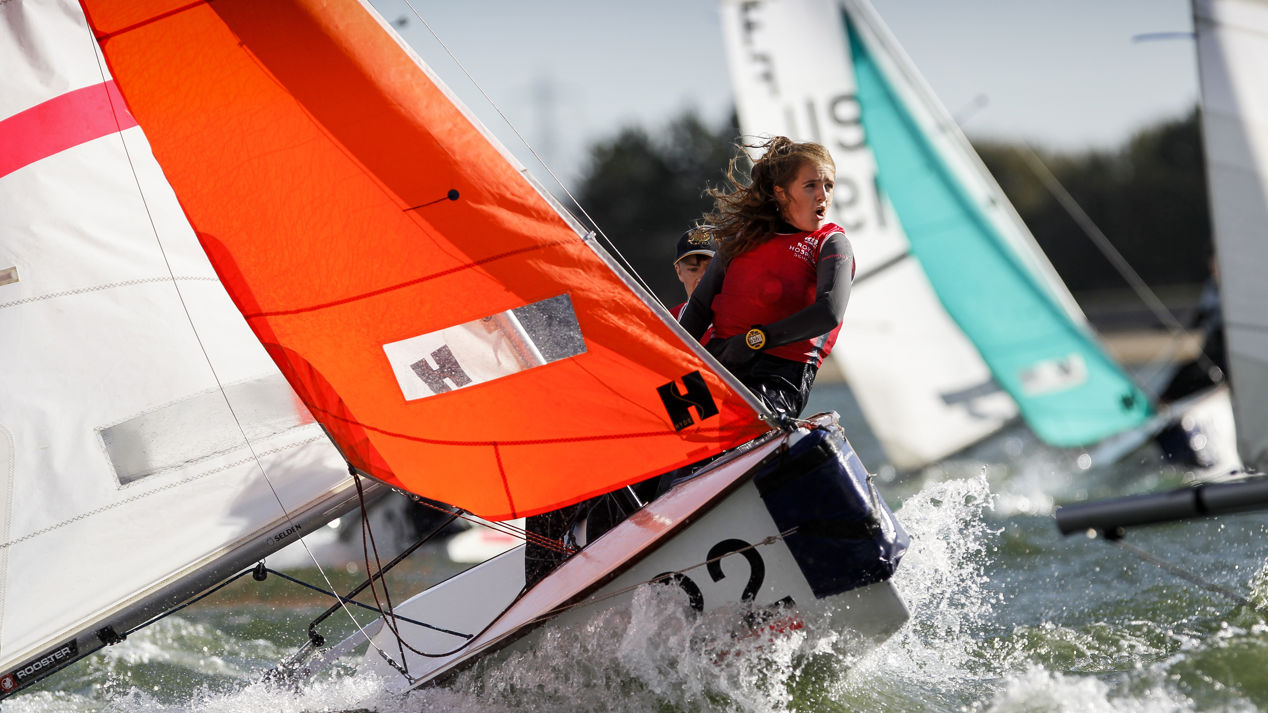 woman leaning back on keelboat during race