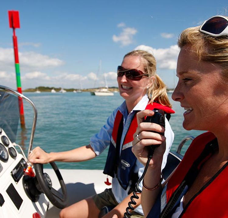 close up of two women using a radio on a boat