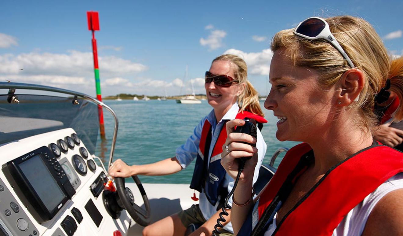 close up of two women using a radio on a boat